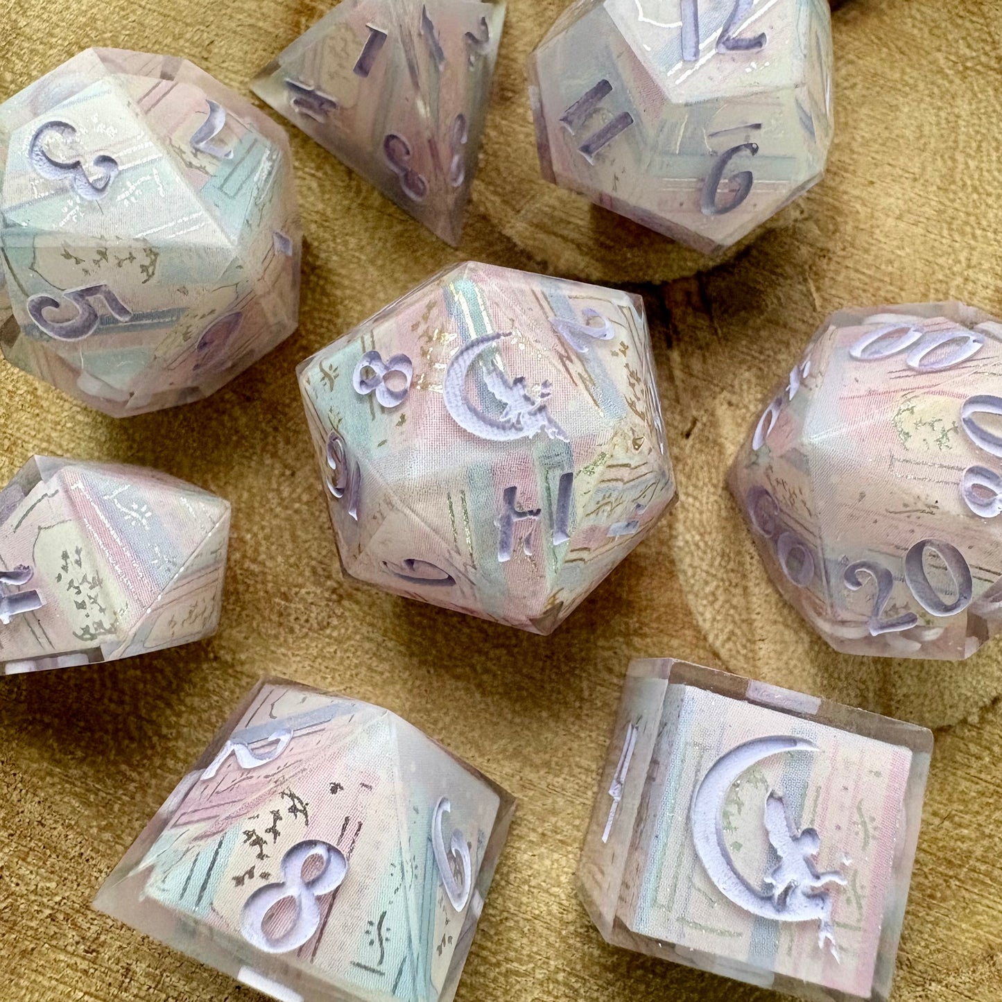 Set of polyhedral dice with a pastel bookshelf motif
