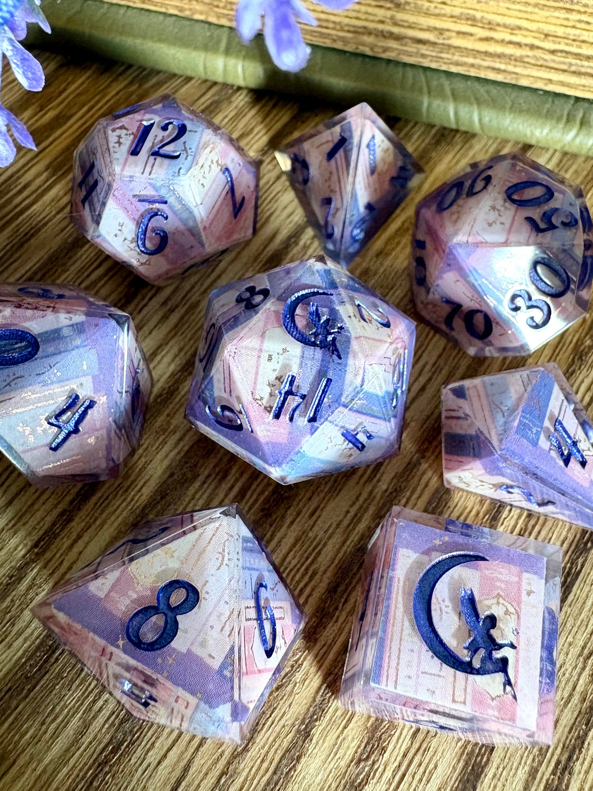 dice set with book spines in pinks, purples, blues and inked in violet