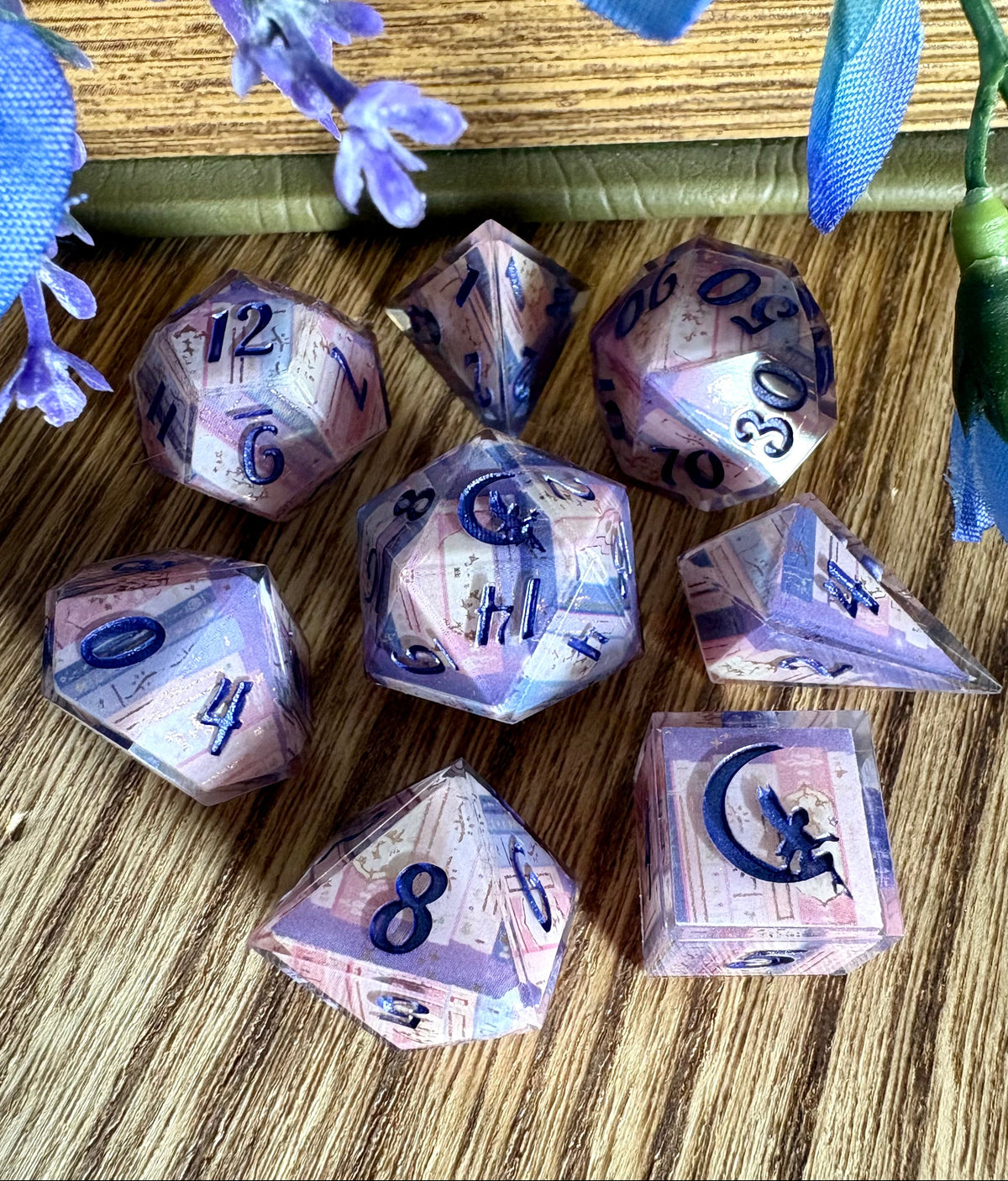 dice set with book spines in pinks, purples, blues and inked in violet